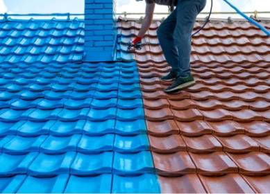Roof painting in progress with spray application on ceramic roof tiles