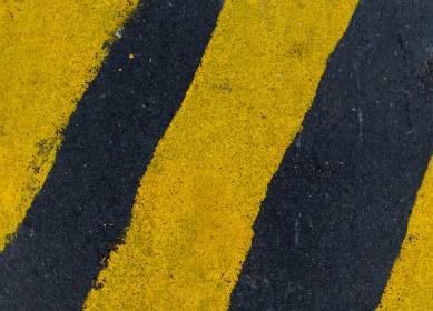 Industrial line marking with reflective yellow and black paint for safety zones