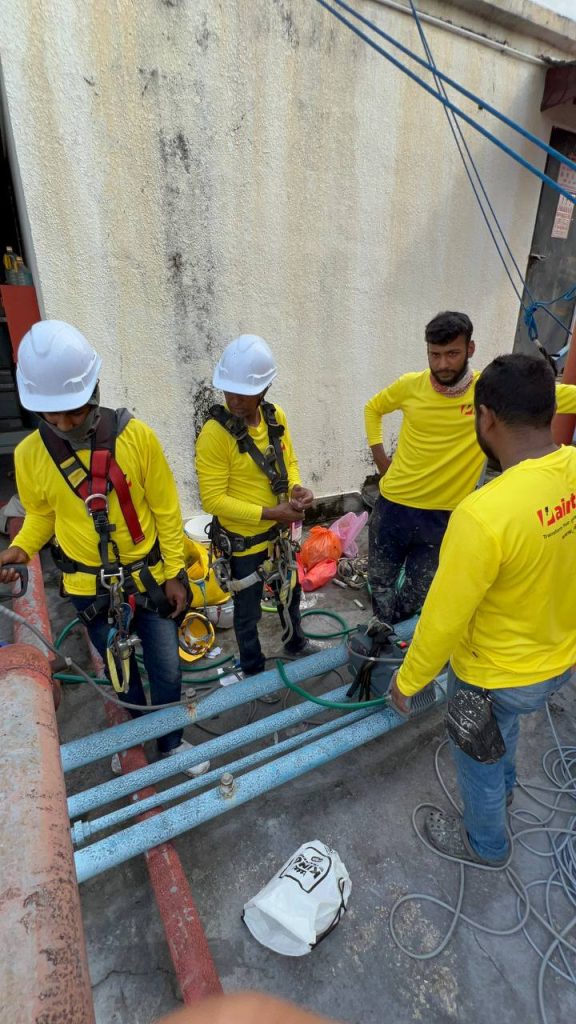 Pekerja Painthero bersedia dengan peralatan keselamatan untuk kerja tali ketinggian.